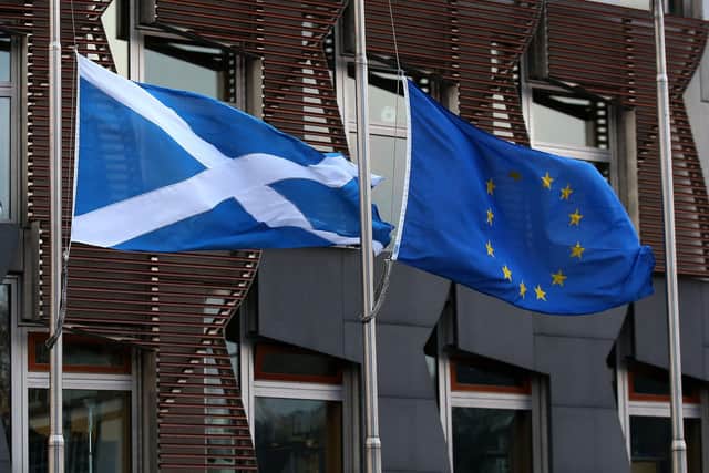 A Saltire and a European Union flag fly outside the Scottish Parliament in Edinburgh