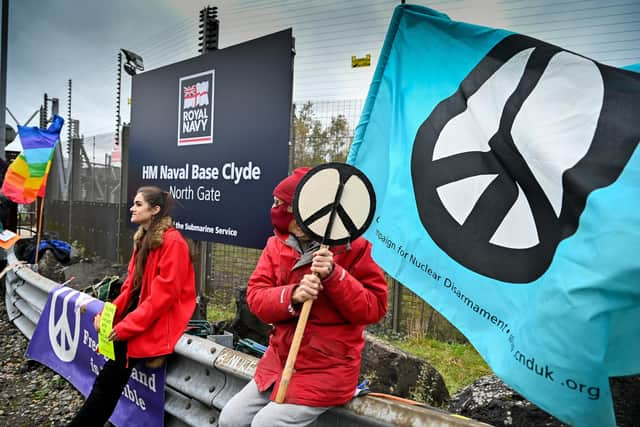 Anti-nuclear campaigners hold banners and placards outside Her Majesty's Naval Base, Clyde in Faslane, Scotland