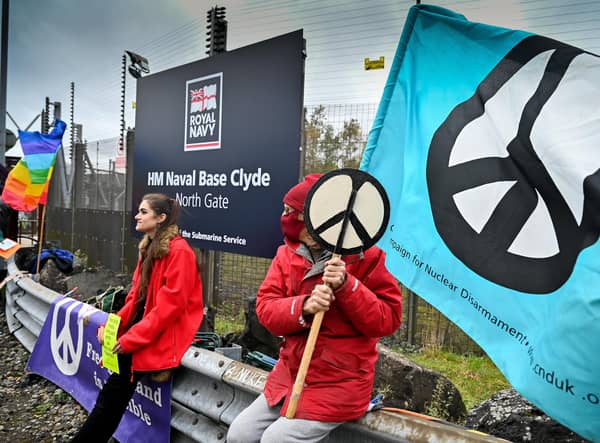 Anti-nuclear campaigners hold banners and placards outside Her Majesty's Naval Base, Clyde in Faslane, Scotland