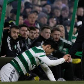 Livingston manager David Martindale helps Celtic midfielder Reo Hatate up after a James Penrice challenge. (Photo by Craig Williamson / SNS Group)