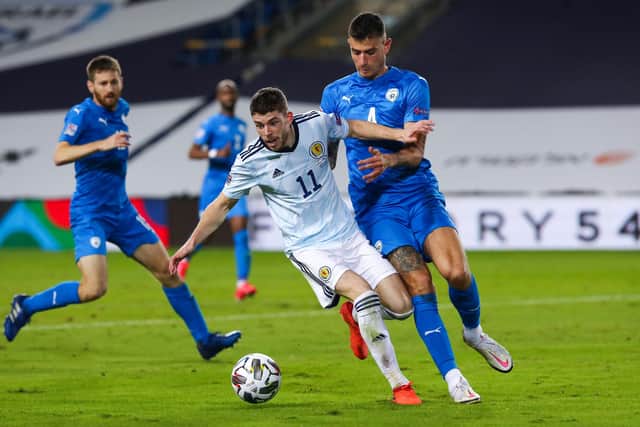 Ryan Christie holds off Israel's Nir Bitton during the teams' last meeting back in November.