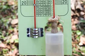 A wet bulb thermometer next to a normal thermometer.