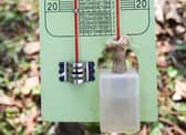 A wet bulb thermometer next to a normal thermometer.