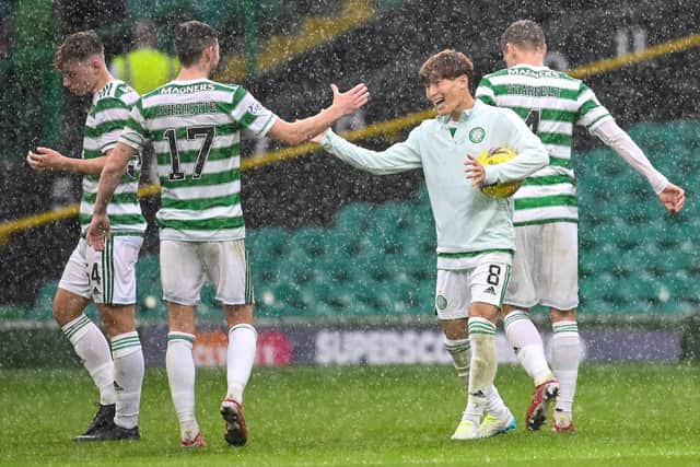 Kyogo Furuhashi embraces team-mate Ryan Christie as he cradles the match ball following his hat-trick against Dundee. Picture: SNS