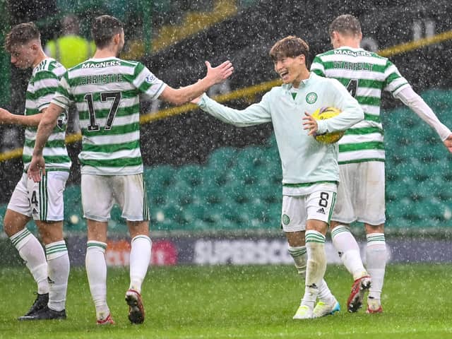 Kyogo Furuhashi embraces team-mate Ryan Christie as he cradles the match ball following his hat-trick against Dundee. Picture: SNS