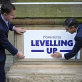 Rishi Sunak and Chancellor Jeremy Hunt fix a 'Powered By Levelling Up' sign onto Accrington Market Hall (Picture: Christopher Furlong/Getty Images)