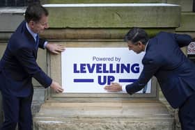Rishi Sunak and Chancellor Jeremy Hunt fix a 'Powered By Levelling Up' sign onto Accrington Market Hall (Picture: Christopher Furlong/Getty Images)
