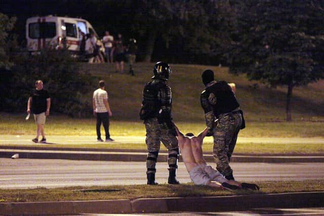 Riot police detain a protester after polls closed in the presidential election, in Minsk on August 9, 2020