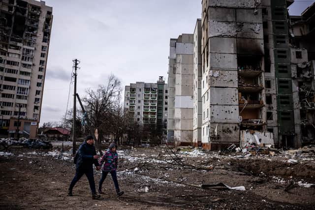 Local people walk in front of flats that were hit by Russian shells in the city of Chernihiv on March 3. Forty-seven people were killed (Picture: Dimitar Dilkoff/AFP via Getty Images)