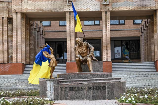 Ukrainian flags placed on statues in a square in Balakliya, Kharkiv region, after Russian occupying troops retreated (Picture: Juan Barreto/AFP via Getty Images)