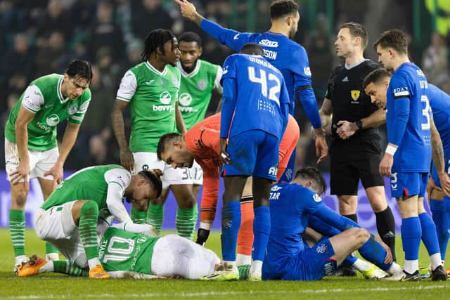 Hibs' Martin Boyle goes down injured after colliding with Rangers' John Souttar.