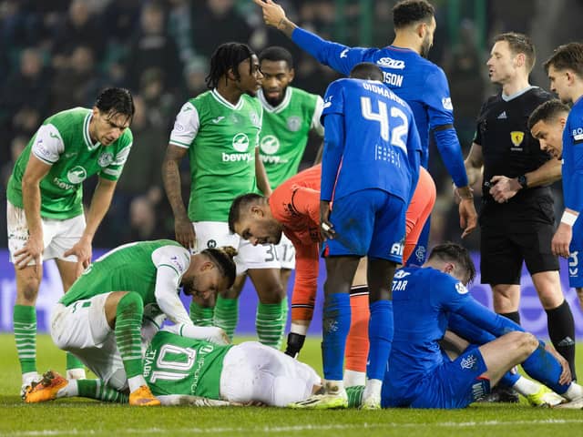 Hibs' Martin Boyle goes down injured after colliding with Rangers' John Souttar.