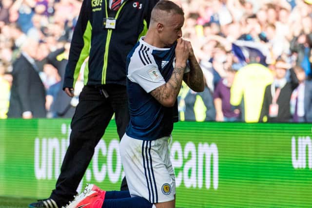 Leigh Griffiths kisses the Scotland crest after curling in his second free-kick in the famous 2-2 draw with England for which the fourth anniversary is now rolling round. (Photo by Alan Harvey/SNS Group).