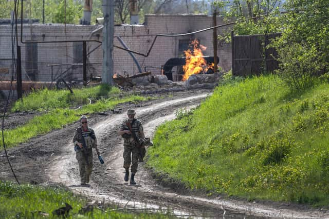 KUkrainian Army soldiers walk past a burning natural gas terminal on the northern outskirts of Kharkiv
(Photo by John Moore/Getty Images)