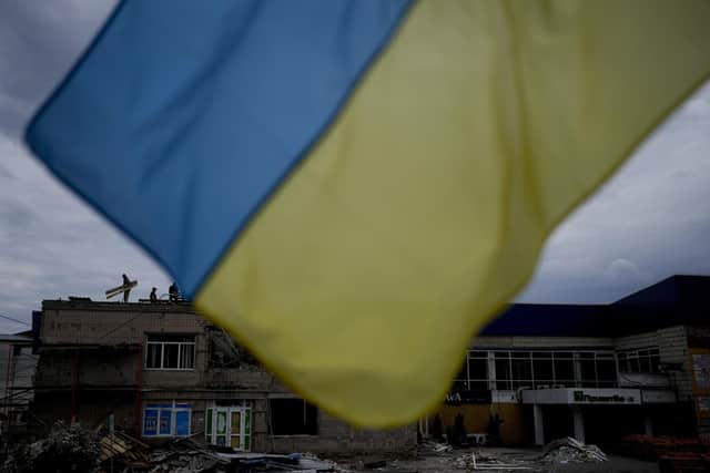 Men work at repairing a building damaged by shelling in Makariv, on the outskirts of Kyiv, Ukraine. Picture: AP Photo/Natacha Pisarenko