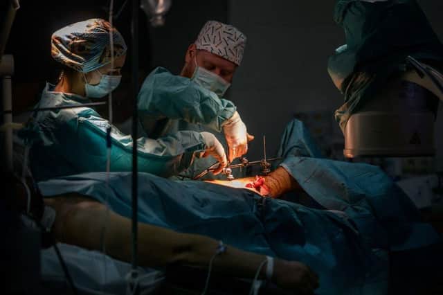 Surgeons perform an operation on the leg of a wounded Ukrainian soldier at a military hospital in Zaporizhzhia.