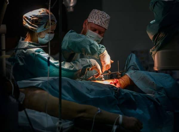 Surgeons perform an operation on the leg of a wounded Ukrainian soldier at a military hospital in Zaporizhzhia.