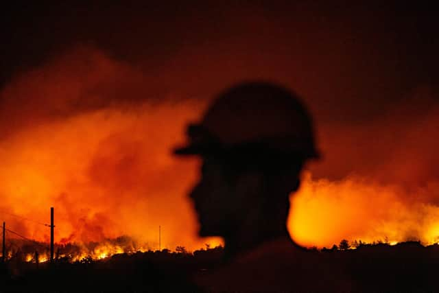 A volunteer firefighter prepares to tackle a fire approaching Akcayaka village in Milas area of Turkey, which has been hit by the worst wildfires in its history, according to President Tayyip Erdogan (Picture: Yasin Akgul/AFP via Getty Images)