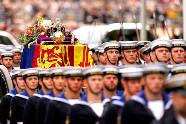 The State Gun Carriage carries the coffin of Queen Elizabeth II, draped in the Royal Standard with the Imperial State Crown and the Sovereign's orb and sceptre, in the Ceremonial Procession following her State Funeral at Westminster Abbey, London. Picture date: Monday September 19, 2022.