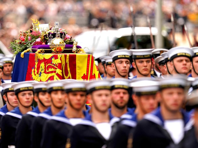 The State Gun Carriage carries the coffin of Queen Elizabeth II, draped in the Royal Standard with the Imperial State Crown and the Sovereign's orb and sceptre, in the Ceremonial Procession following her State Funeral at Westminster Abbey, London. Picture date: Monday September 19, 2022.