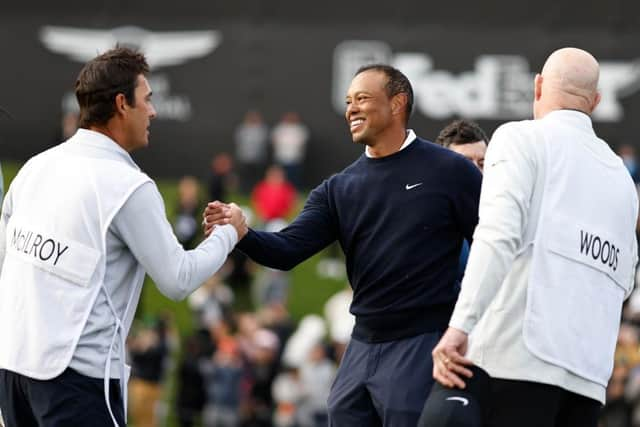 The smile on his face says it all as Tiger Woods shakes hands with Harry Diamond, Rory McIlroy's caddie, after finishing with three straight birdies in the first round of The Genesis Invitational at Riviera Country Club in Pacific Palisades, California. Picture: Michael Owens/Getty Images.