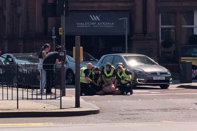Police in Edinburgh have been photographed wrestling a half-naked man to the ground outside the Caledonian Hotel on Princes Street this afternoon.