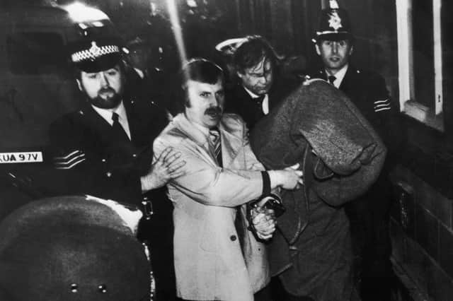 His head covered with a blanket, Peter Sutcliffe, the so-called Yorkshire Ripper, is escorted into Dewsbury Magistrates Court to be charged with murder in January 1981. (Picture: Jack Hickes/Keystone/Hulton Archive/Getty Images)