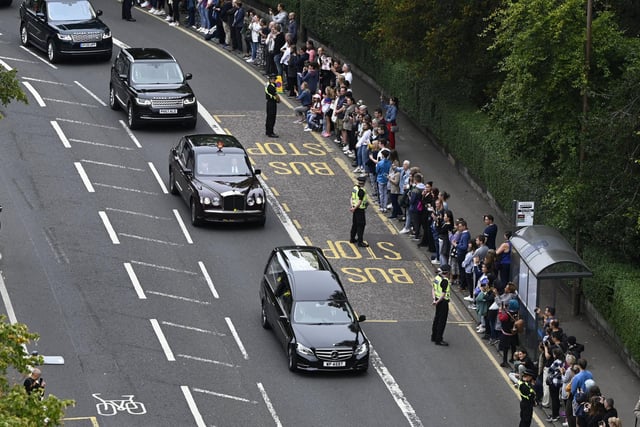 The hearse carrying the coffin of Queen Elizabeth II, draped with the Royal Standard of Scotland, passing through the outskirts of Edinburgh as it continues its journey to the Palace of Holyroodhouse from Balmoral. Picture date: Sunday September 11, 2022.
