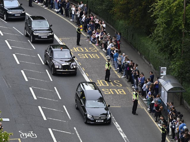 The hearse carrying the coffin of Queen Elizabeth II, draped with the Royal Standard of Scotland, passing through the outskirts of Edinburgh as it continues its journey to the Palace of Holyroodhouse from Balmoral. Picture date: Sunday September 11, 2022.