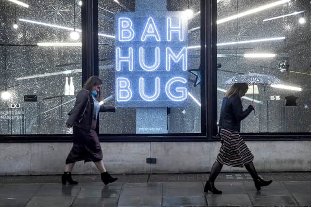 Two women are seen walking past a shop display with a sign reading 'Bah Humbug' last Christmas. Photograph: Peter Summers