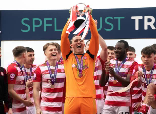 Man-of-the-match Ryan Fulton lifts the SPFL Trust Trophy after a tremendous performance against Raith Rovers.