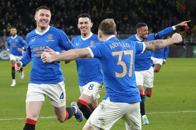 Rangers' John Lundstram, left, celebrates with the team after a goal during the Europa League Play-off, 1st leg soccer match between Borussia Dortmund and Rangers in Dortmund, Germany, Thursday, Feb. 17, 2022. (AP Photo/Martin Meissner)