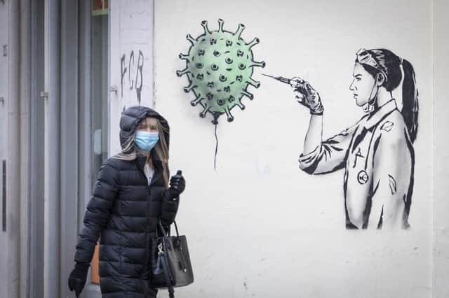 A member of the public walks past new artwork created by street artist The Rebel Bear in Edinburgh city centre