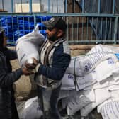 Displaced Palestinians receive food aid at the United Nations Relief and Works Agency for Palestine Refugees (UNRWA) center in Rafah in the southern Gaza Strip (Photo by -/AFP via Getty Images)