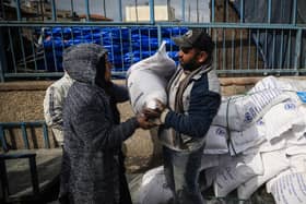 Displaced Palestinians receive food aid at the United Nations Relief and Works Agency for Palestine Refugees (UNRWA) center in Rafah in the southern Gaza Strip (Photo by -/AFP via Getty Images)