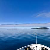 A boat approaches the Isle of Canna, which sits to the south west of Skye. A crowdfunding appeal has been launched to help build new houses on the island to help grow its population. PIC: NTS.