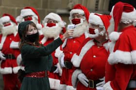 Santas have their temperature taken as they attend a socially distanced Santa school training at Southwark Cathedral in London