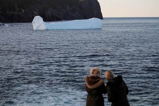 Two people watch an iceberg float off Flatrock, Newfoundland, Canada, which is about as far north as Brittany in France (Picture: Drew Angerer/Getty Images)