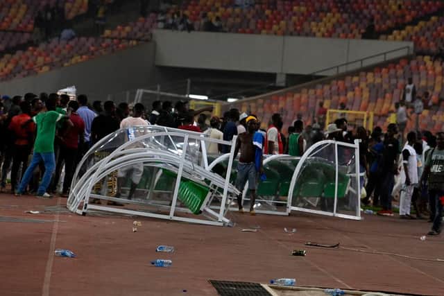 Angry football fans break the players' bench as violence broke-out following Ghana's defeat over Nigeria at the World Cup 2022 qualifying football match between Nigeria and Ghana at the National Stadium in Abuja on March 29, 2022. (Photo by PIUS UTOMI EKPEI/AFP via Getty Images)