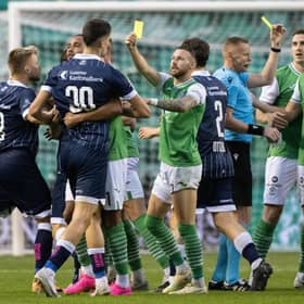 Hibs winger Martin Boyle jokingly shows a yellow card to his opponents while referee Robertas Valikonis books Joe Newell for real during the Europa Conference League third qualifying round match between the Leith side and FC Luzern at Easter Road.  Photo by Paul Devlin / SNS Group