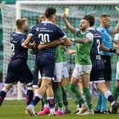 Hibs winger Martin Boyle jokingly shows a yellow card to his opponents while referee Robertas Valikonis books Joe Newell for real during the Europa Conference League third qualifying round match between the Leith side and FC Luzern at Easter Road.  Photo by Paul Devlin / SNS Group