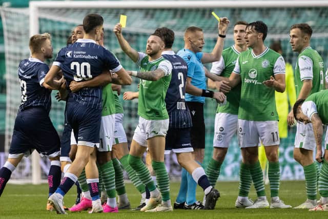 Hibs winger Martin Boyle jokingly shows a yellow card to his opponents while referee Robertas Valikonis books Joe Newell for real during the Europa Conference League third qualifying round match between the Leith side and FC Luzern at Easter Road.  Photo by Paul Devlin / SNS Group