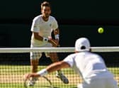 Cameron Norrie faces a Novak Djokovic serve during the men's singles semi final match at Wimbledon. (Photo by SEBASTIEN BOZON/AFP via Getty Images)