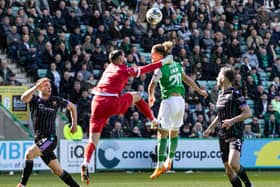 St Johnstone's Dimitar Mitov collides with Hibs' Emiliano Marcondes in the penalty box.