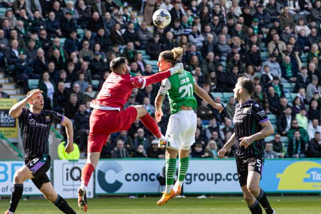 St Johnstone's Dimitar Mitov collides with Hibs' Emiliano Marcondes in the penalty box.