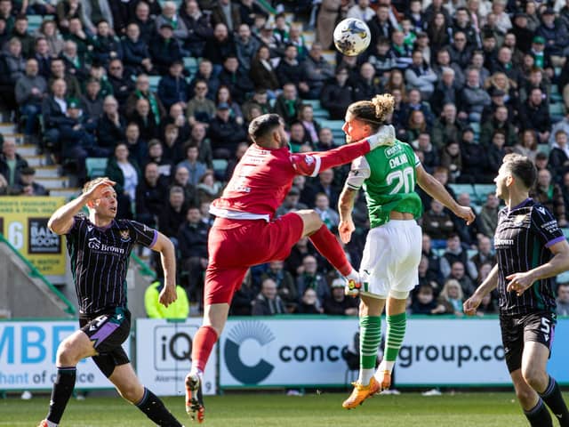 St Johnstone's Dimitar Mitov collides with Hibs' Emiliano Marcondes in the penalty box.