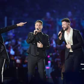 Howard Donald and Gary Barlow of Take That, perform with Callum Scott (right) on stage during the Coronation Concert