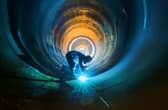 An employee works on a wind turbine tower at a factory in Lianyungang, in China's eastern Jiangsu province (Picture: STR/AFP via Getty Images)
