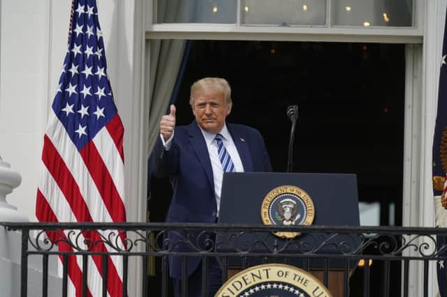 President Donald Trump gives a thumbs up from the Blue Room Balcony of the White House to a crowd of supporters in Washington on Saturday. Picture: Alex Brandon/AP