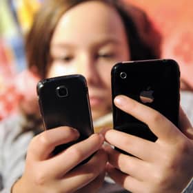 A child using mobile phones. Image for illustration only. (Photo by DENIS CHARLET/AFP via Getty Images)